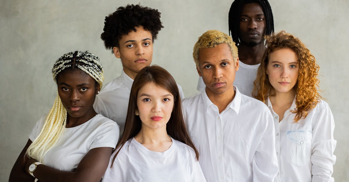 How good are dentists in the United Kingdom? [closed] - Serious diverse multiracial people standing close together representing concept of unity  and looking at camera against gray background