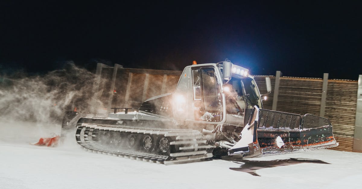 How hard Is it to drive in winter at night in Iceland? - Snowplow removing snow near fence How hard Is it to drive in winter at night in Iceland? - Snowplow removing snow near fence