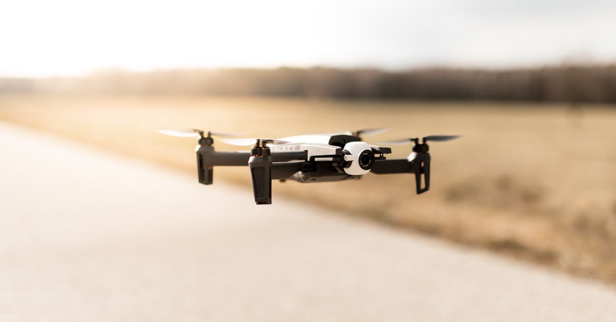 How is the air traffic before thanksgiving? - Soft focus of modern quadcopter flying above road out of city near forest