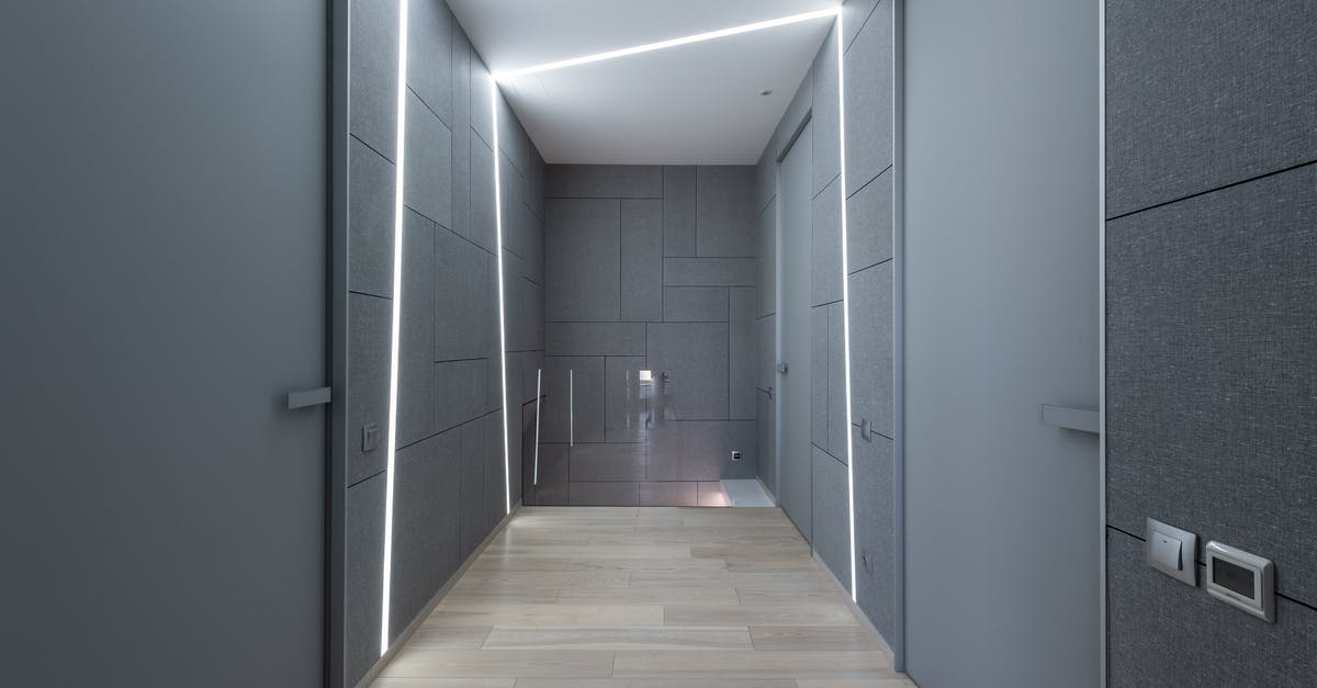 How long can I extend a hotel stay? [closed] - Interior of contemporary hallway of creative space with parquet and gray walls with doors and modern bright illumination on ceiling and walls