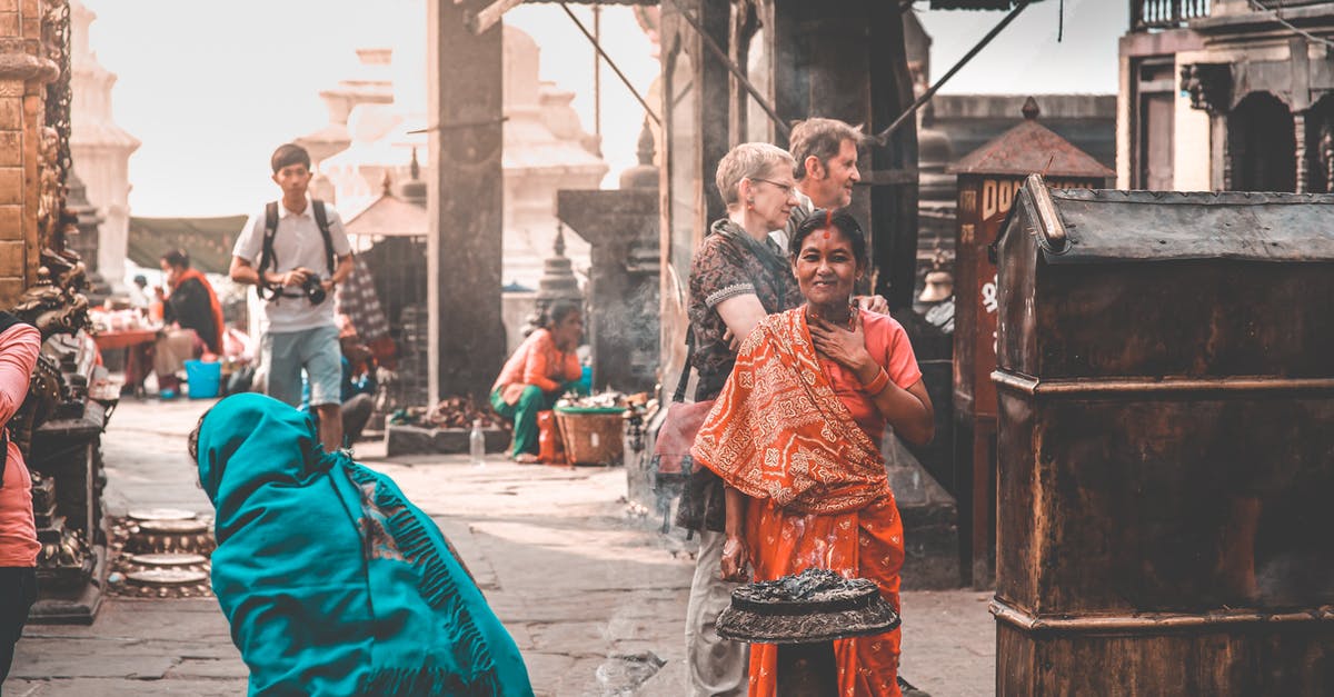 How long can I stay in Nepal on a tourist visa? - Local Nepali people in traditional clothes and travelers walking on paved street of old town on sunny day