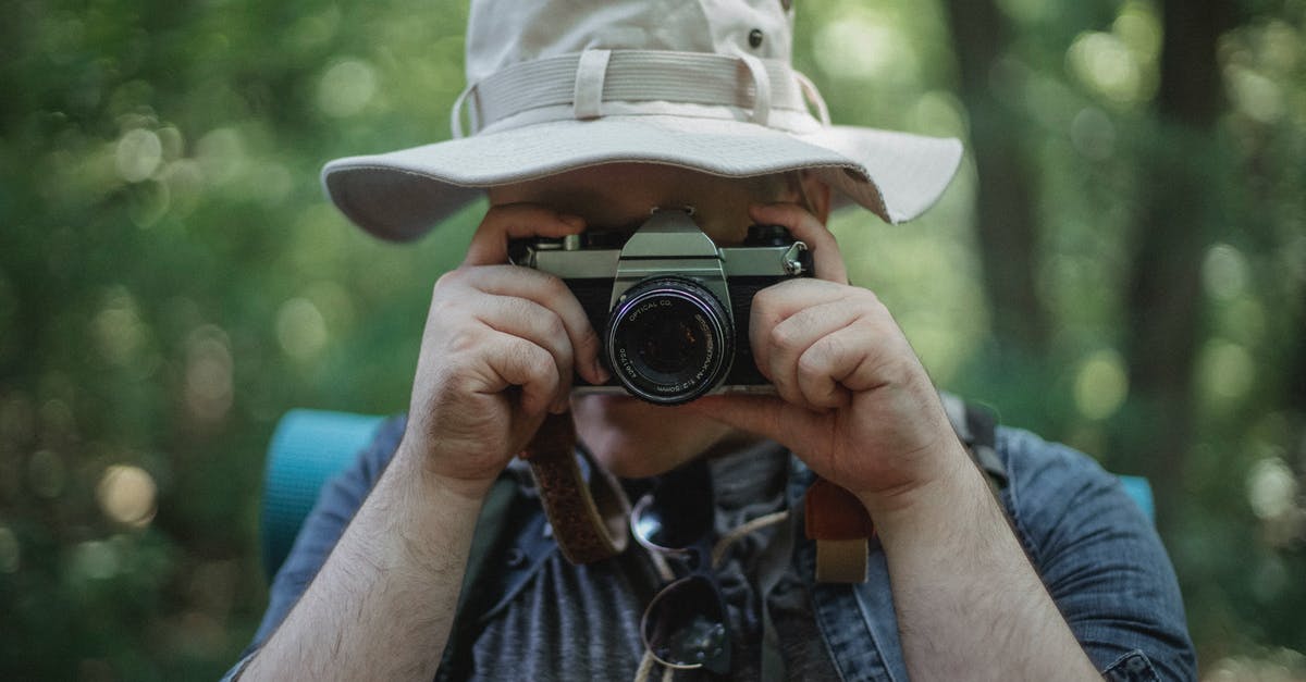 How long does the tourist visa extension process take in Guangzhou, China? - Anonymous tourist taking photo on camera in woods