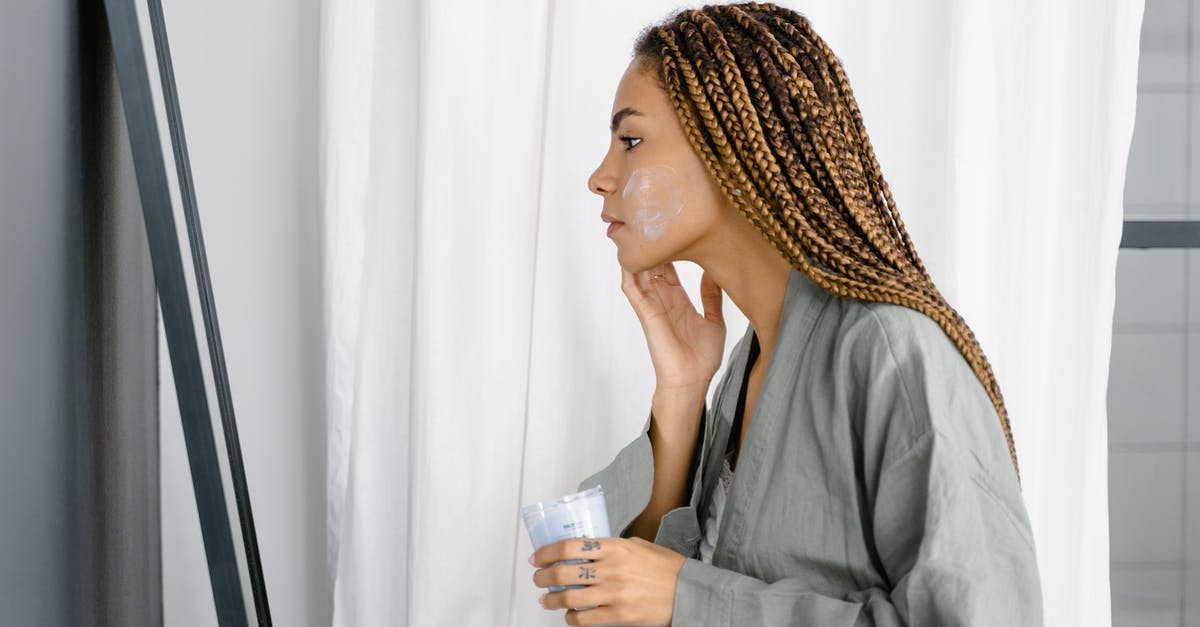 How long should I wait before applying for a visa after being refused entry? - A Braided Hair Woman Applying a Cream on Her Face