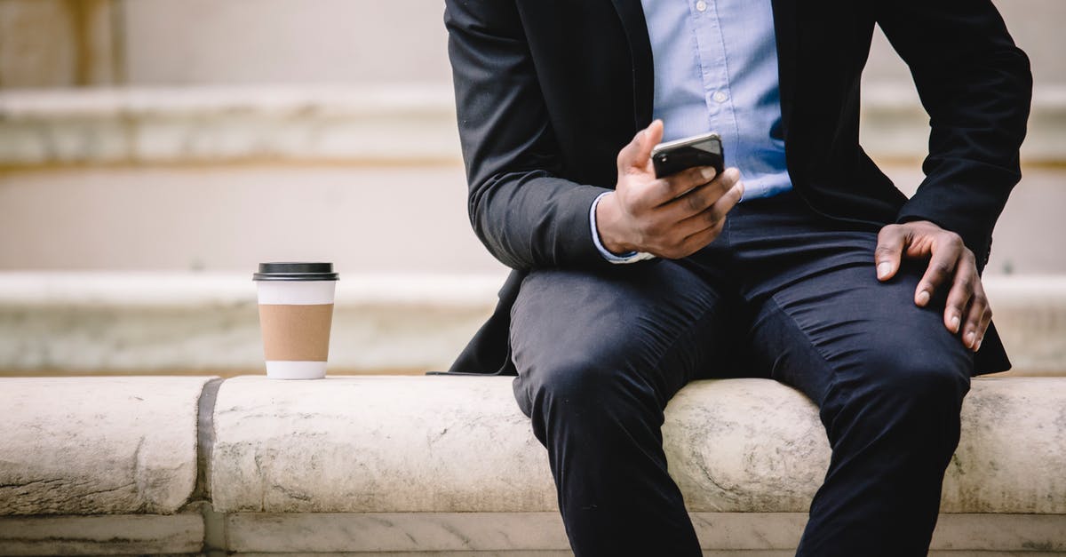 How manageable are <15 min connection times in Frankfurt Hbf? - Crop faceless male manager in formal wear sitting on marble bench and messaging on mobile phone during coffee break