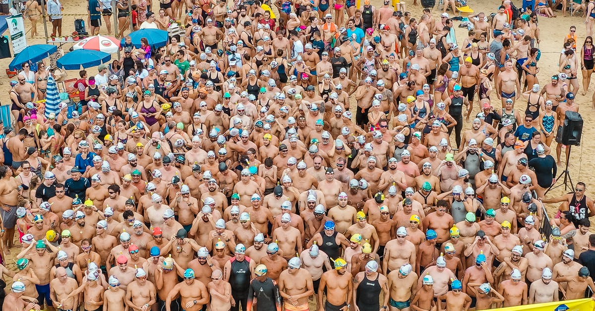 How many beaches are suitable for swimming in Cebu City? - From above people in swimsuits standing together behind line tape ready to start swim marathon on seashore