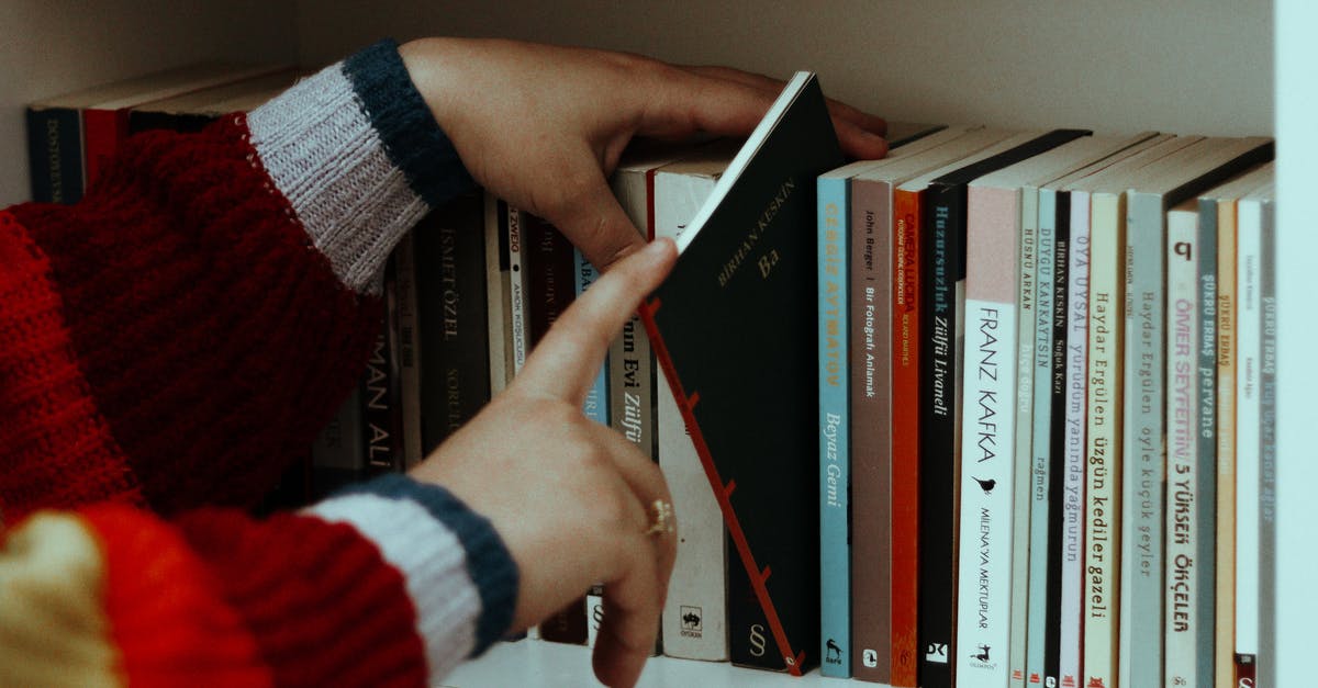 How many laptops can I take to UK? - Woman in striped sweater choosing books on shelf