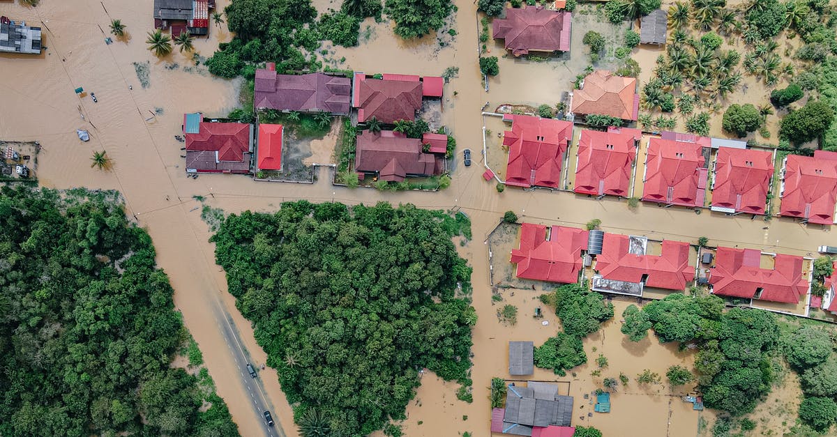 How many years am I banned from entering the Schengen Area? - Overhead view of colorful roofs of residential buildings and lush green trees in flooded small village