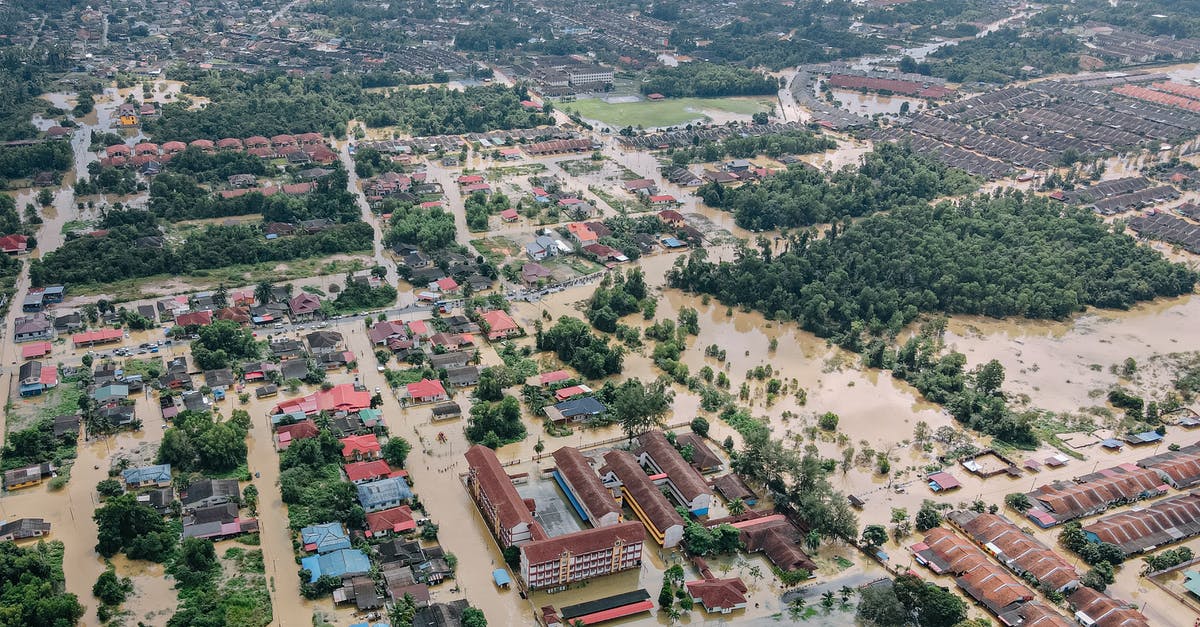 How many years am I banned from entering the Schengen Area? - Aerial view of flooded small town with many residential houses and lush green trees