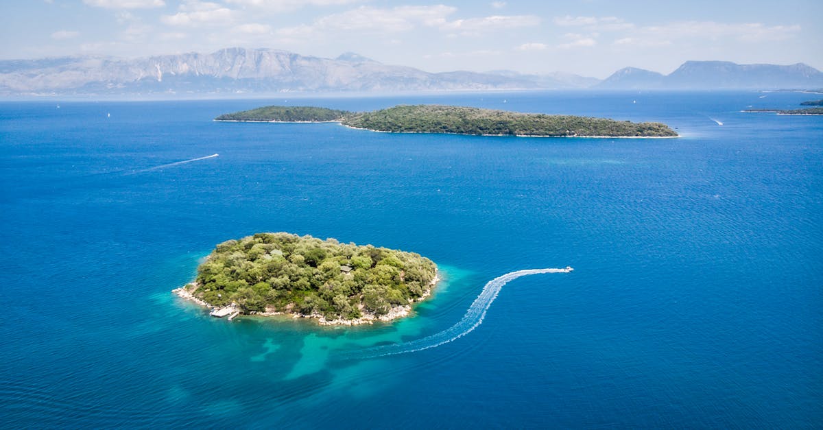 How much is a boat trip from Venezuela to Trinidad? - Amazing aerial view of boats floating in turquoise sea near islands with lush green vegetation on sunny day