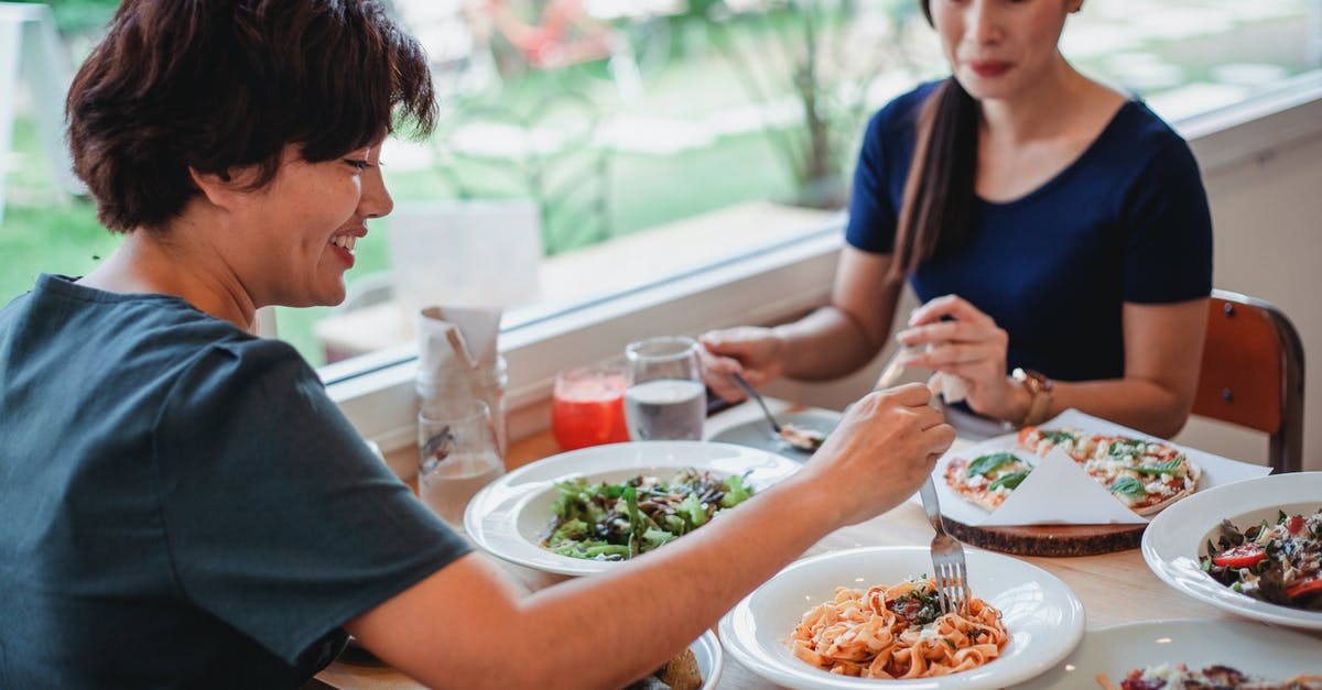 How much to tip for a free meal in Mexico? - Asian women having lunch in restaurant