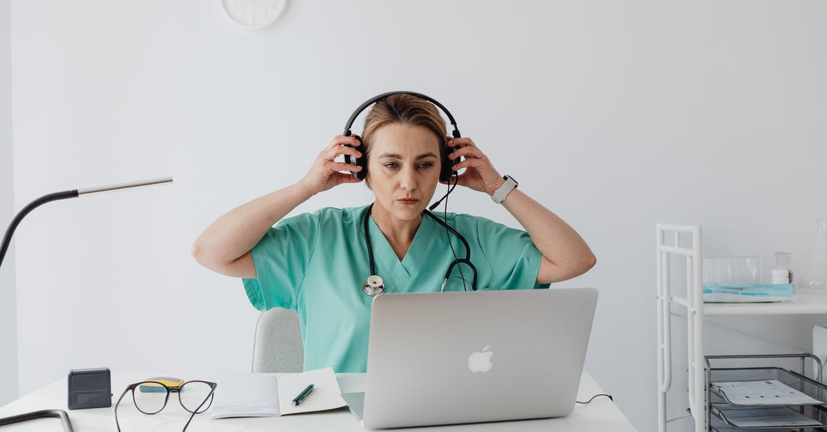 How reliable are portable WiFi hotspots in Japan? - A Woman in Teal Shirt Sitting Near the Table with Laptop while Wearing a Headset