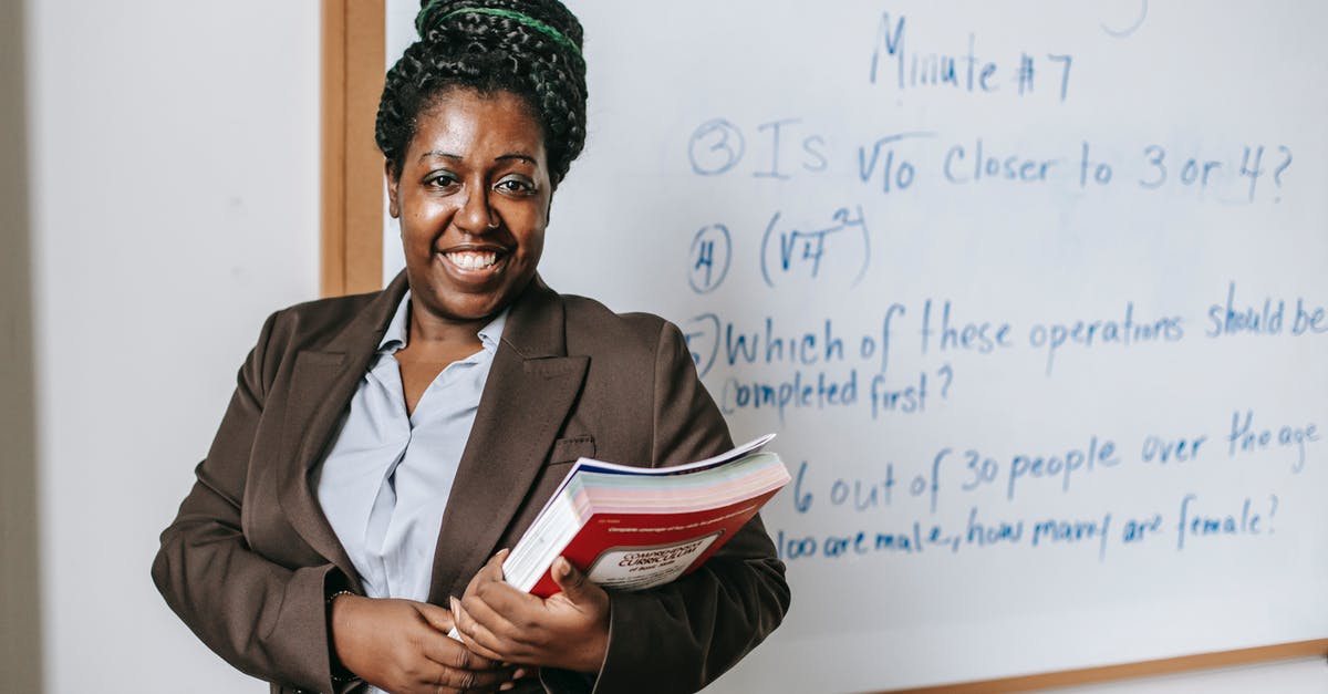 How reliable is the booking site Trazy? - Cheerful black female teacher with workbooks standing near whiteboard