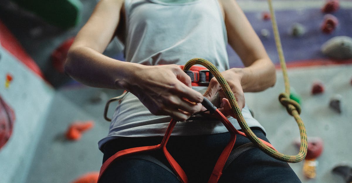 How safe are cable cars? - From below of crop anonymous female climber putting on cable of belay during preparation for climbing training