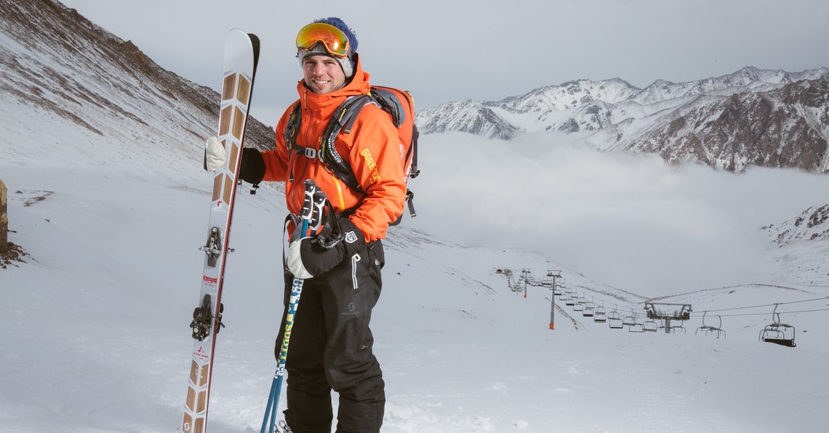 How safe are cable cars? - Man Wearing Orange and Black Snowsuit With Ski Set on Snow Near Cable Cars