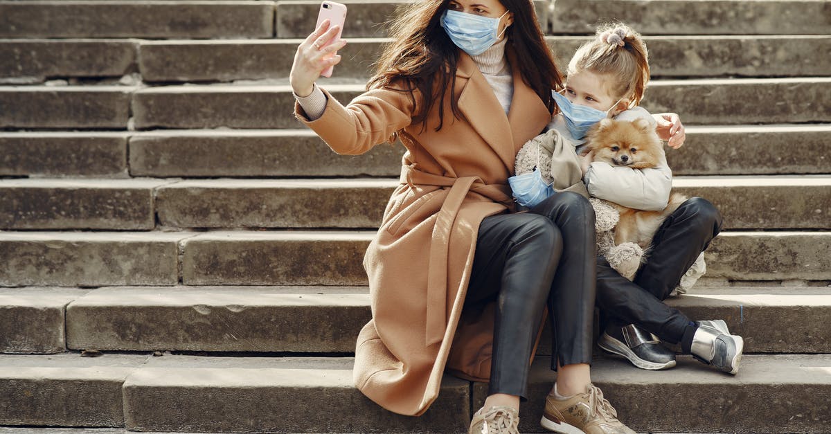 How safe it is for a dog to go through Johannesburg Airport customs? - Full body of female and adorable little girl in casual clothes and medical masks sitting on steps with toy in mask and cute dog taking photo on smartphone