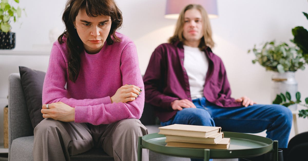 How severe will language problem be in Germany? - Woman in Pink Sweater Sitting Beside Woman in Gray Sweater