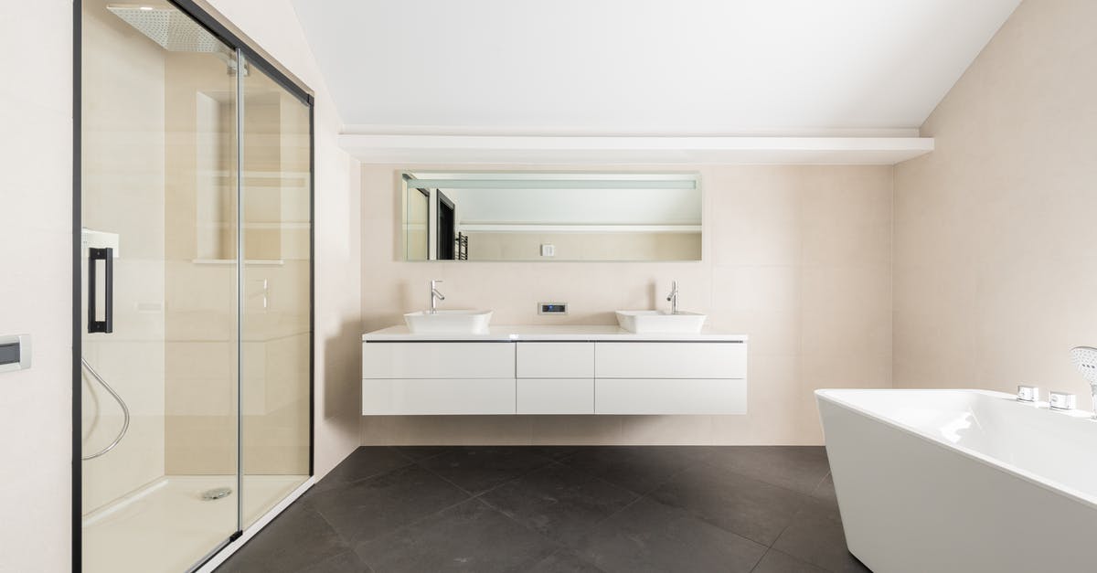 How to adapt to Western Toilets from Indian-style toilets? - Interior of spacious modern bathroom with shower cabin bathtub and minimalist furniture in contemporary apartment