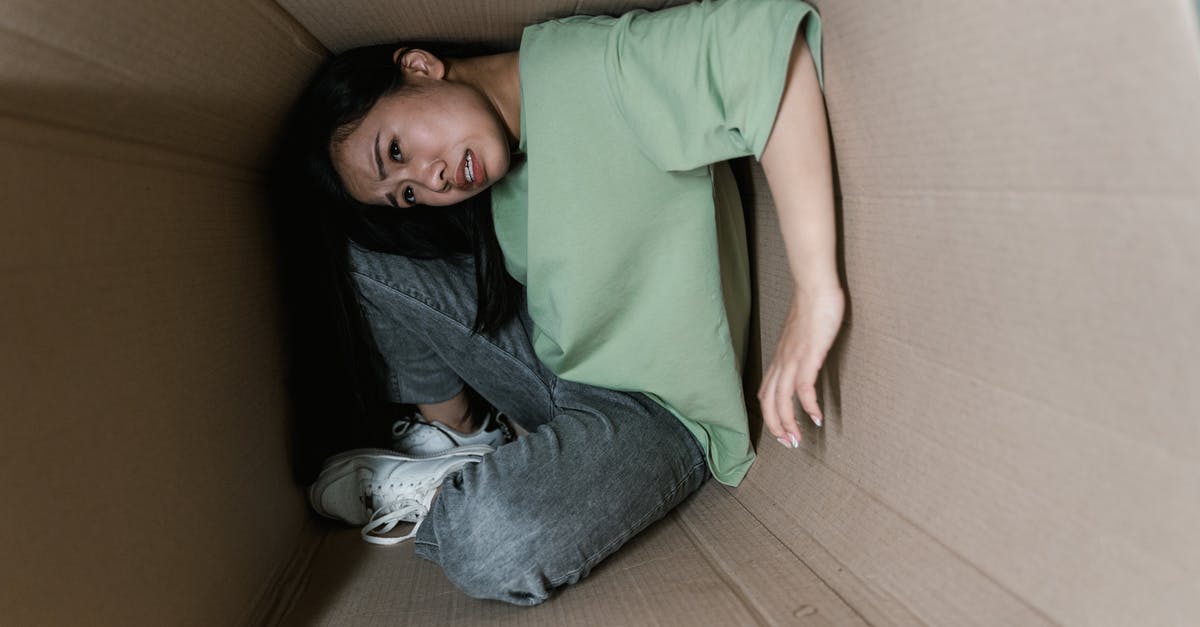 How to avoid claustrophobia on a plane? - A Fearful Woman Having Claustrophobia in a Cardboard Box