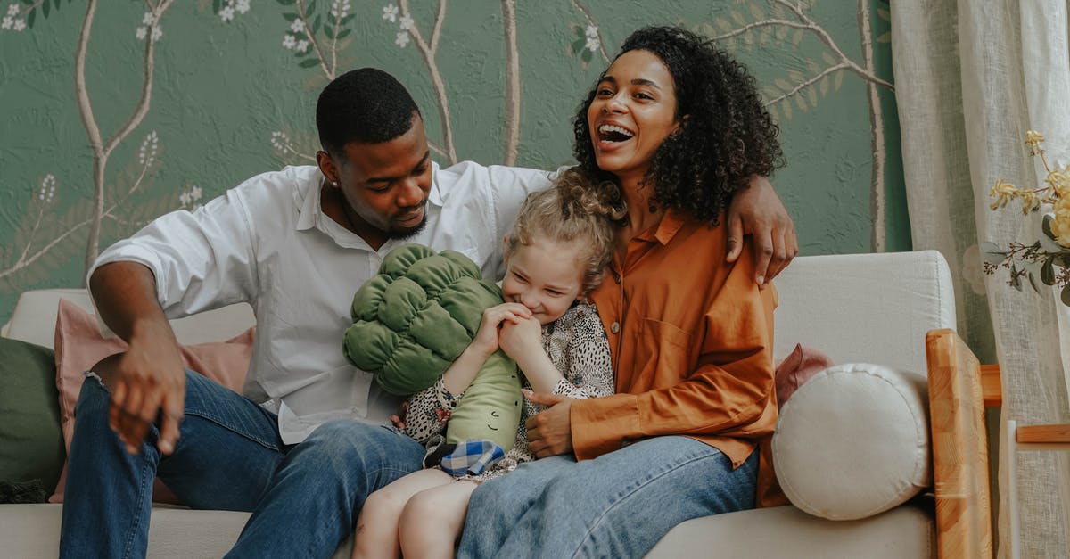 How to bring non-EU parents to live in the UK? [closed] - A Happy Couple Sitting on a Couch  with their Daughter