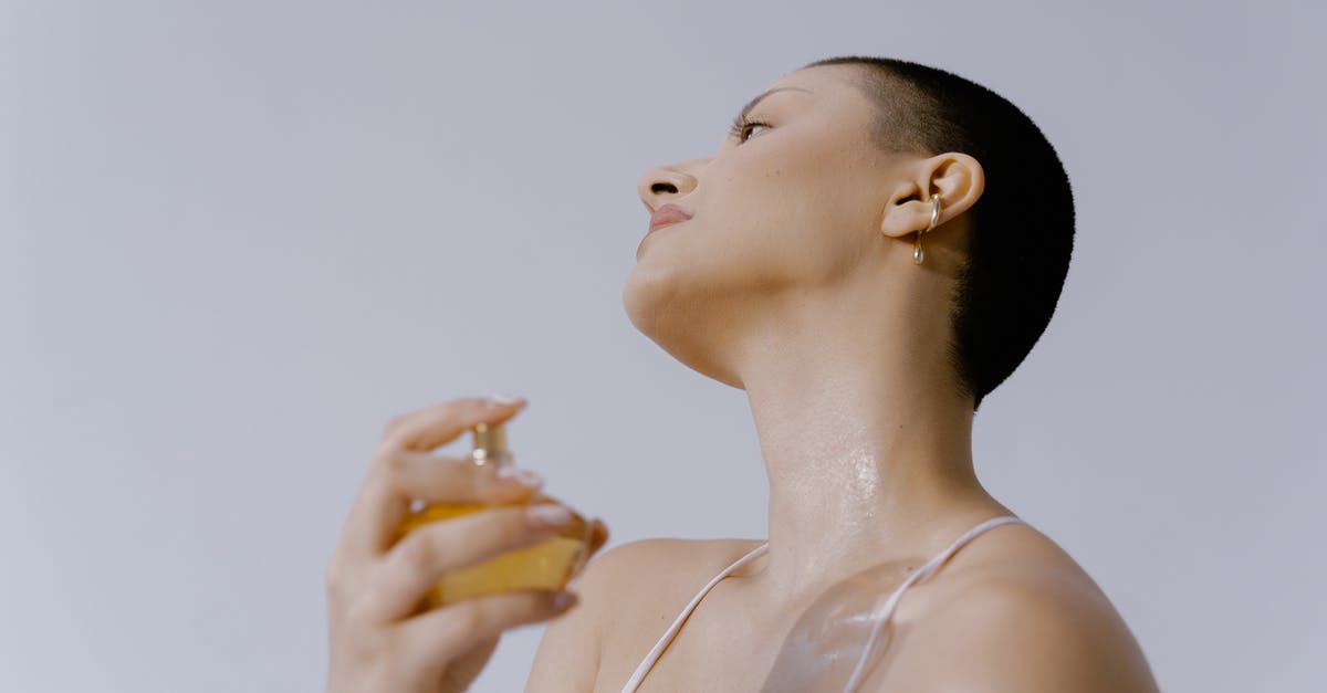 How to carry cologne bottles in hand luggage and prevent losses? - Woman Spraying Perfume on Her Neck