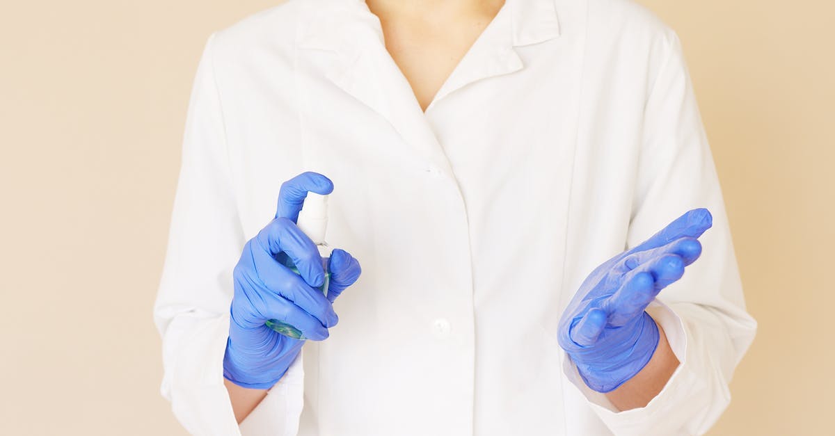 How to carry cologne bottles in hand luggage and prevent losses? - Crop unrecognizable hospital worker in white uniform spraying antiseptic liquid over hands in blue latex gloves