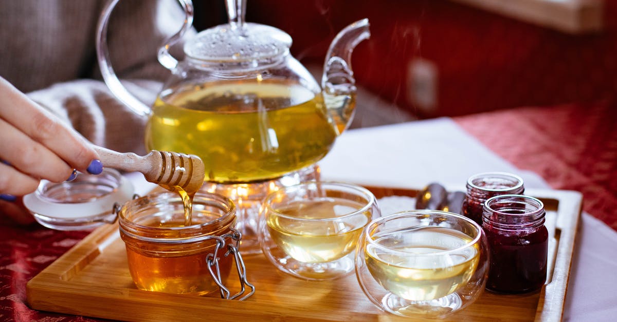 How to carry honey jars and prevent losses? - Person Holding Honey Stick With Teapot