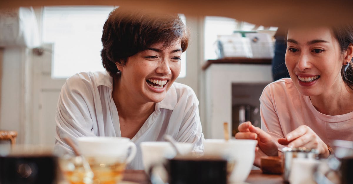 How to choose where and how long to have my layover - Happy young ethnic ladies having fun in store near table with dishware