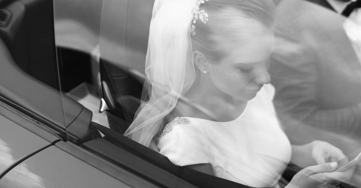 How to decline CDW and LDW when booking a car online? - From above black and white of woman in veil text messaging on cellphone near crop anonymous man in automobile on wedding day