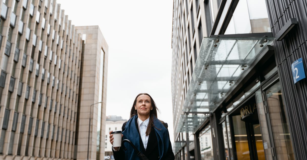 How to divide large bank notes into smaller ones while traveling? - Woman in Black Coat Standing Near Building