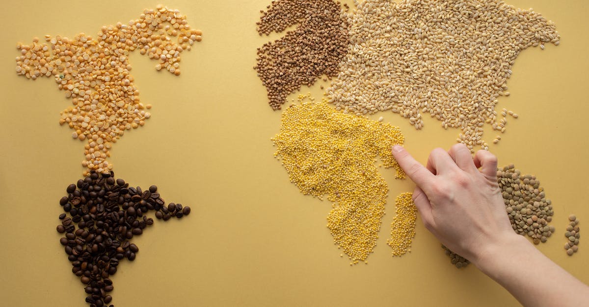 How to dry clothes while travelling in winter? - Top view of crop unrecognizable traveler making world continents with assorted grains and coffee beans on yellow background in room