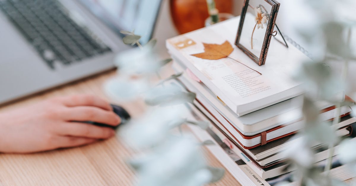 How to dry shirts using laundromats? - Crop unrecognizable distance worker browsing internet on netbook against textbooks and dry leaf on table in house