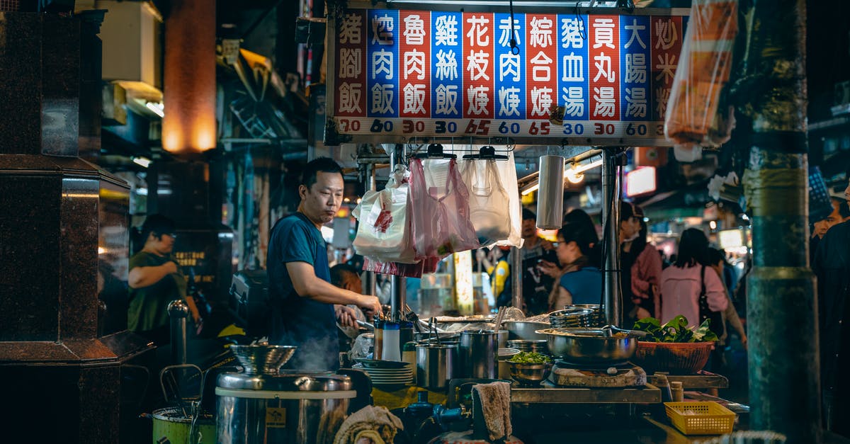 How to find a Thomas Cook flight number? [duplicate] - Side view of thoughtful male cook looking down while preparing food at table with bowls under colorful signboard with hieroglyphic inscriptions and numbers near customers at night