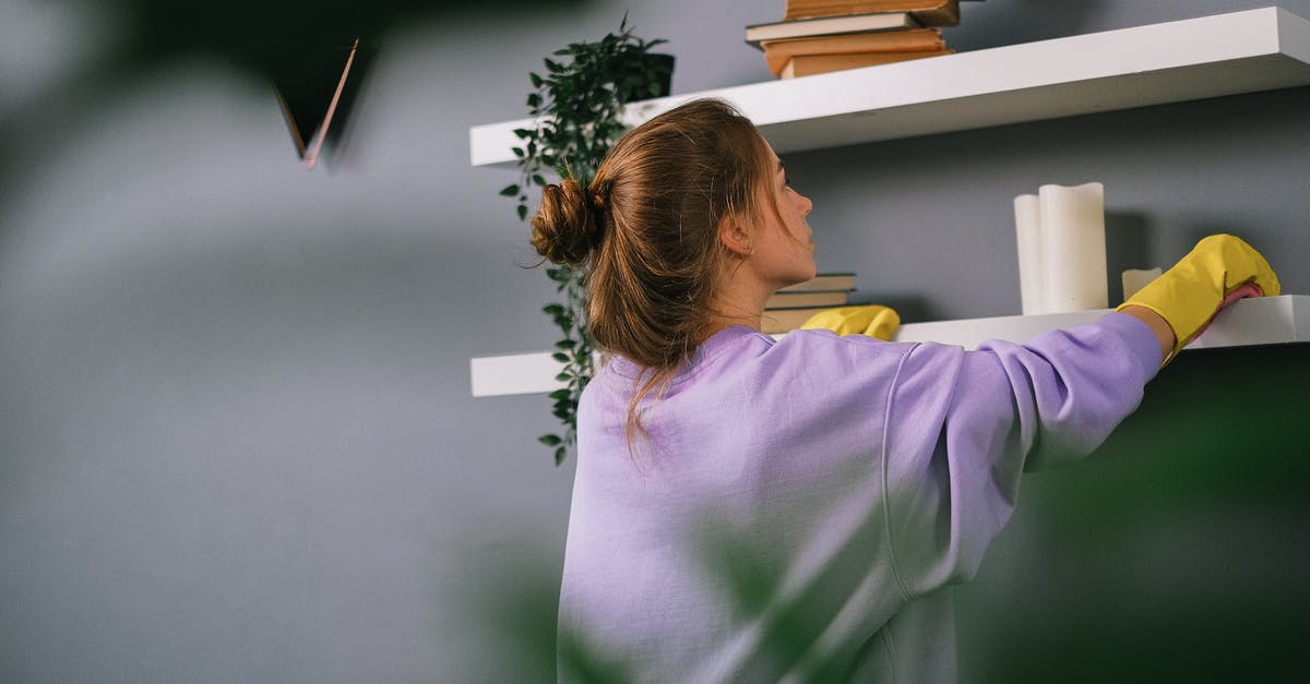 How to find accommodation when what you reserved appears to be overbooked, or worse, non-existent? - Young female wiping shelves in room with gray wall How to find accommodation when what you reserved appears to be overbooked, or worse, non-existent? - Young female wiping shelves in room with gray wall