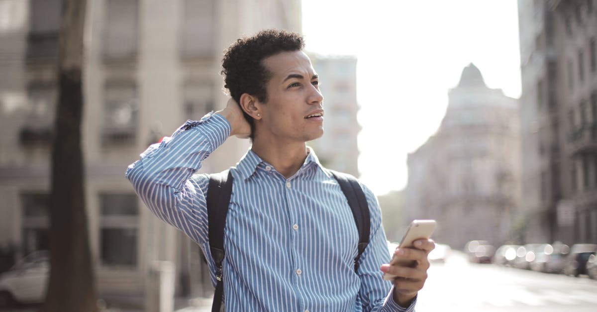 How to find the nearest location which has sunny forecast - Thoughtful man using smartphone on street