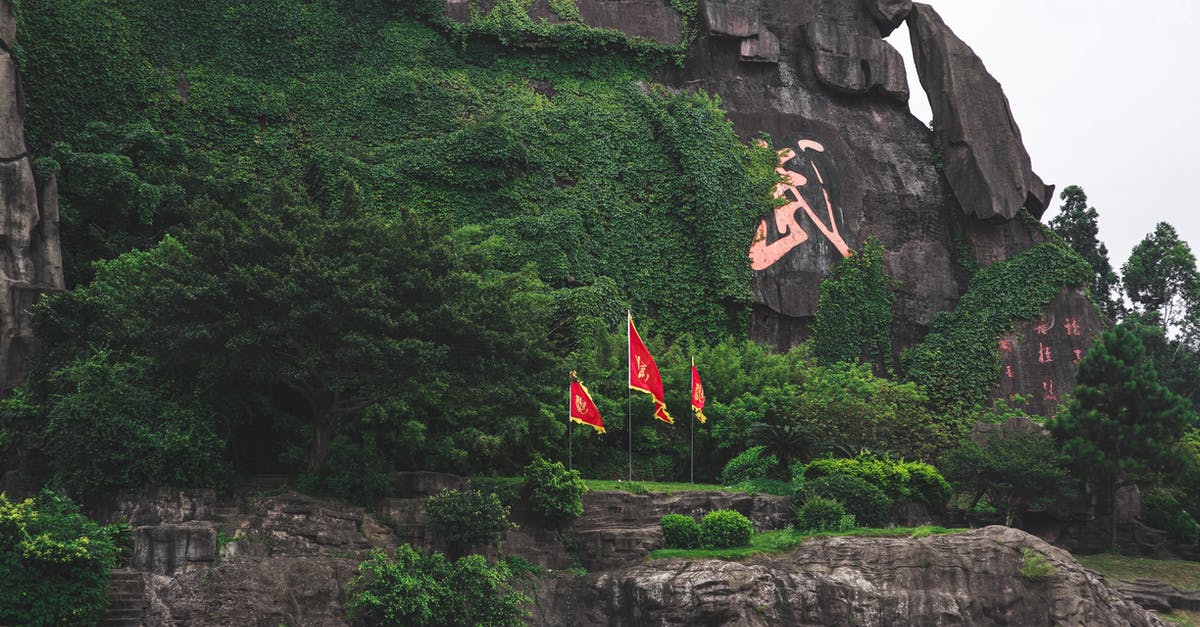 How to fix name spelling when flying on China Southern Airlines? - Mountain range with plants and national flags in summer