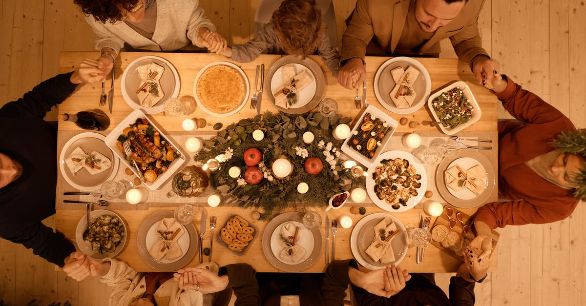 How to get a Schengen visa from Saudi Arabia? - Top View of a Family Praying Before Christmas Dinner