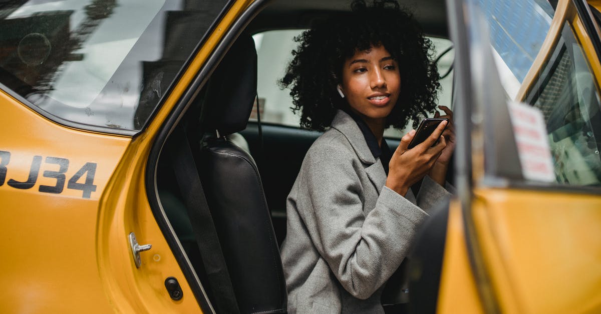 How to get a taxi on Prague streets? - Black woman getting out of taxi on street