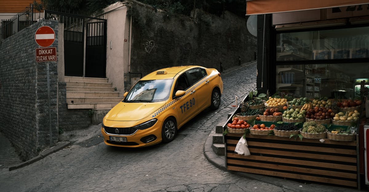 How to get a taxi on Prague streets? - Yellow Car Parked Beside Brown Wooden Bench