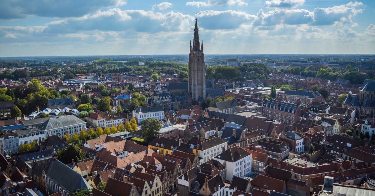 How to get from Breskens to Bruges by bus? - Spectacular drone view of Church of Our Lady and aged red roofed buildings in historical center of Bruges on sunny day