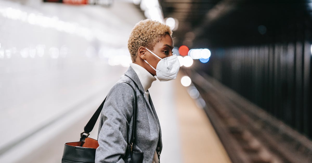 How to get updated about current incidents and safety concerns? - Pensive black woman in mask standing on railway platform