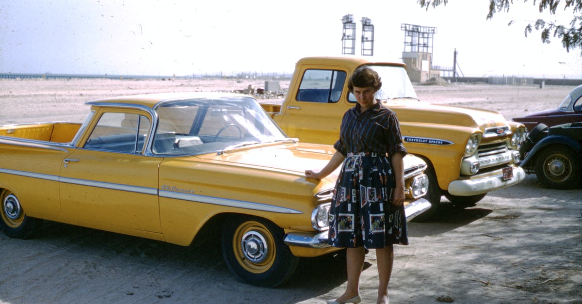 How to independently visit Saudi Arabia? - Woman in Black and White Floral Dress Leaning on Yellow Car