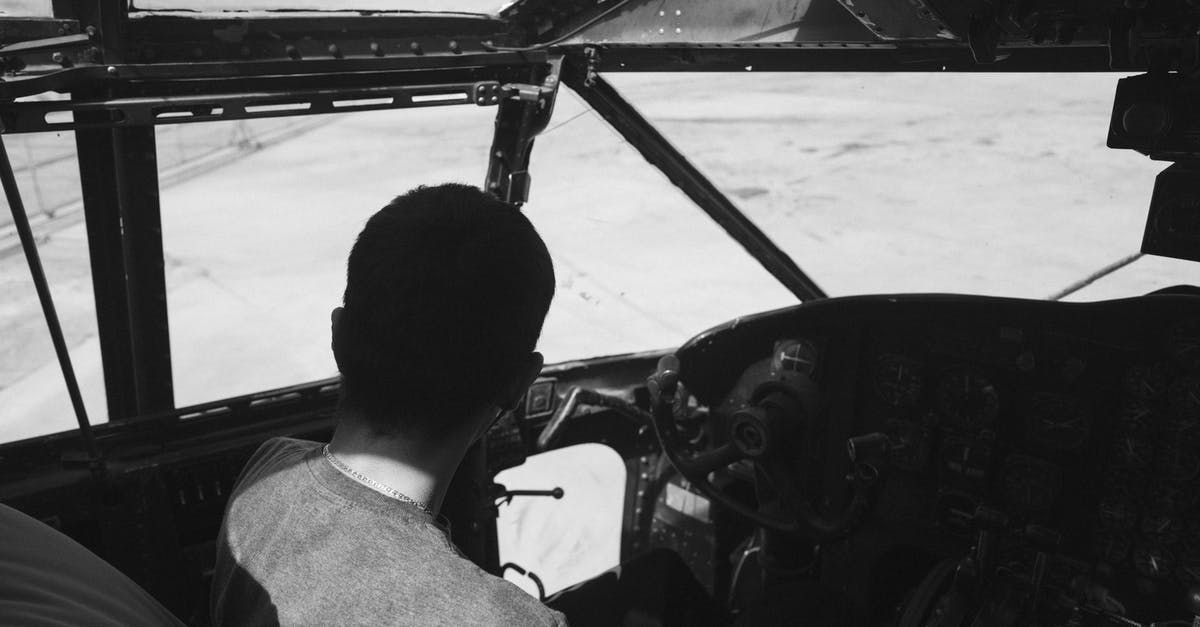 How to insure professional equipment while traveling - Unrecognizable person sitting in pilot cabin during flight