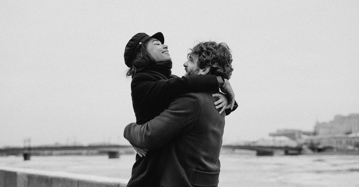 How to interpret the end date for Thailand's tourist visa exemption's temporary extension to 45 days? - Monochrome Photo of Man Hugging His Woman