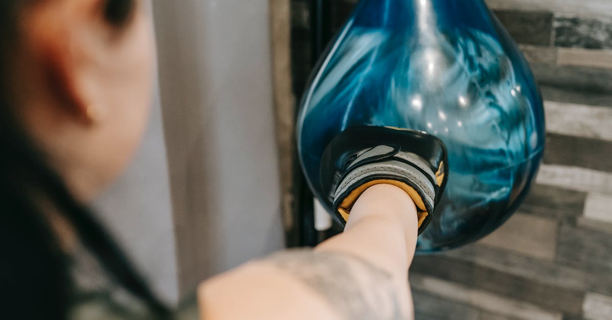 How to join the bile-high club if there's no airsick bag? - Woman punching heavy boxing bag during training