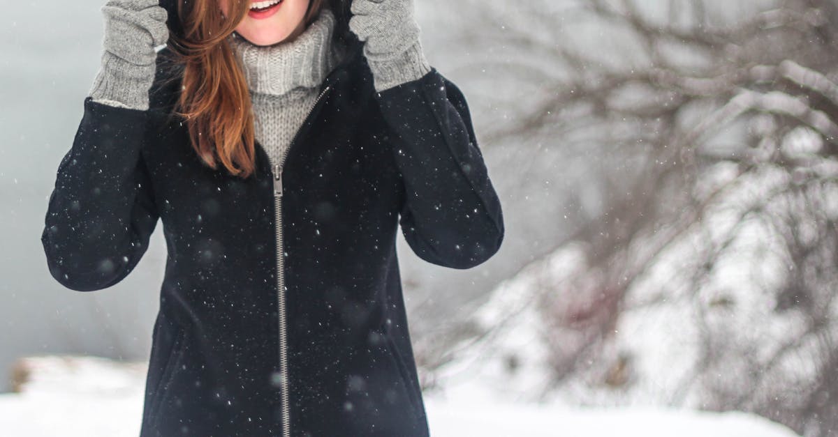 How to keep electronics warm in cold countries? - Woman Standing While Holding Her Jacket