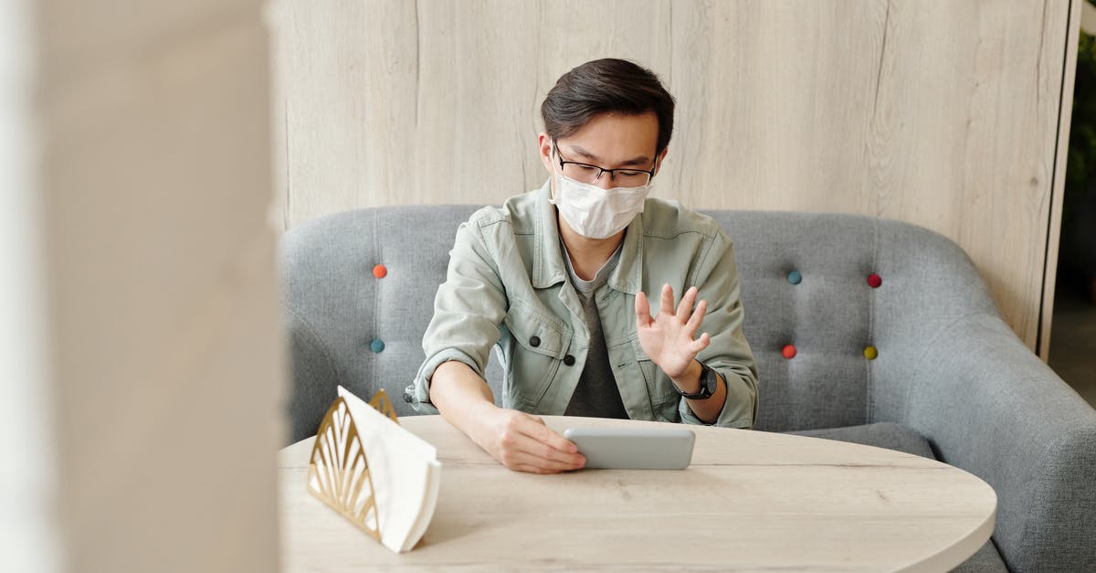 How to make an international emergency call? - Man Wearing A Face Mask Having A Video Call