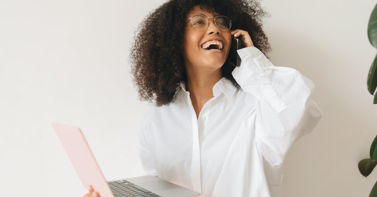 How to make cheapest calls from France (Mobile) to India (Mobile)? - Woman in White Dress Shirt Having a Phone Call while Holding a Laptop