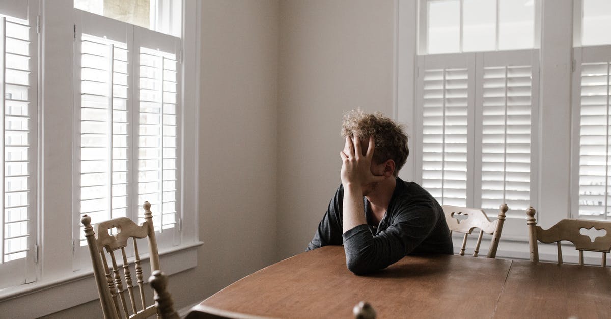 How to make dining alone less awkward? - Photo of Man Leaning on Wooden Table