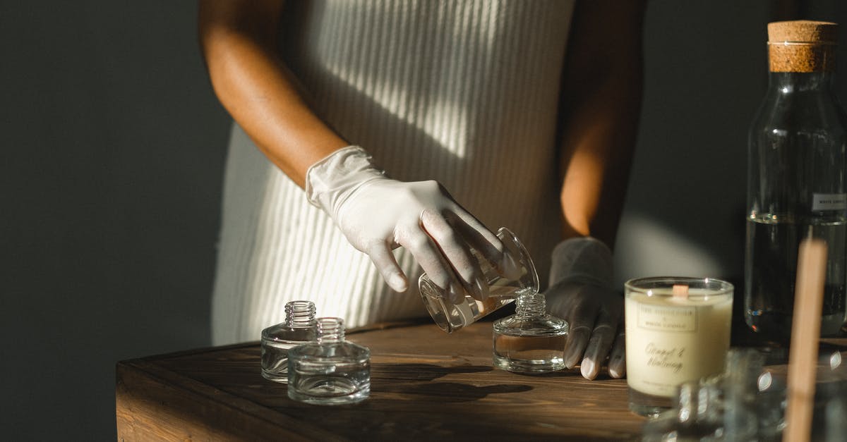 How to make sure luggage makes it across multiple airlines? - Unrecognizable crop African American female pouring essential oil in glass bottle while making liquid incense at table