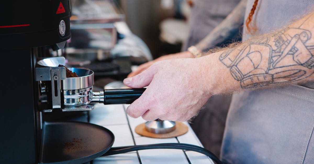 How to make the best use of signs while hitchiking? - Tattooed man preparing coffee with coffee machine